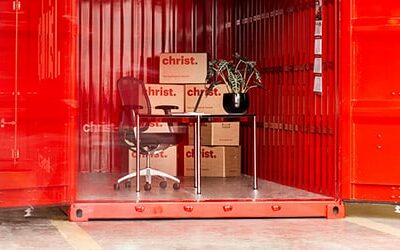 Umzugskartons und Möbel in einem roten Container