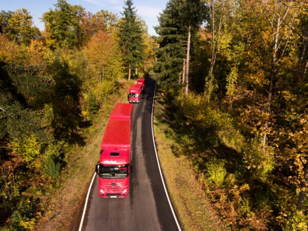 Christ Logistik LKWs fahren auf Landstraße - Sicht von oben